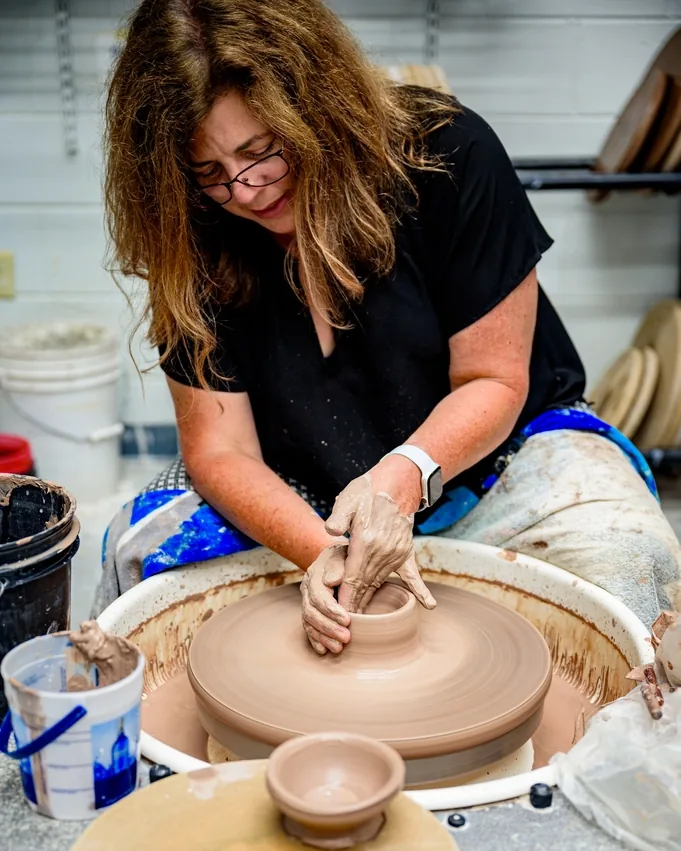 Hannah, the artist behind Juniper Row Pottery, throwing a bowl at her wheel