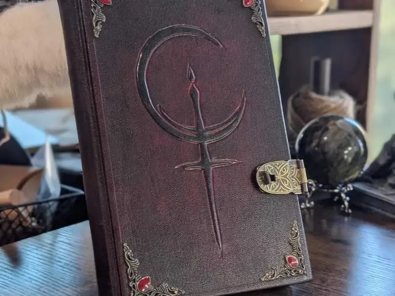 Handmade dark red leather journal with a crescent moon cover and a metal clasp, from Velimira Designs
